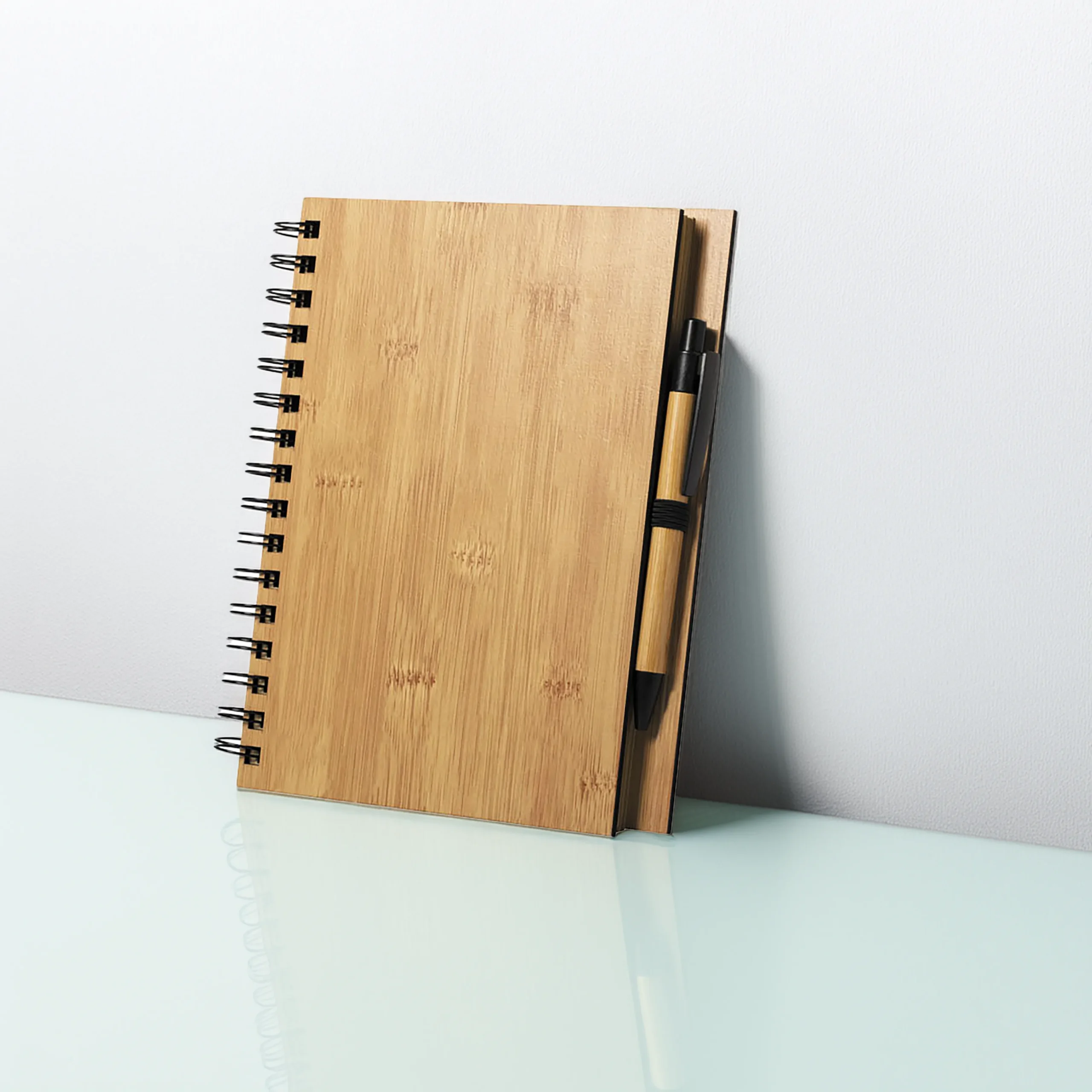 Set de libreta y bolígrafo en madera ecológica con espiral metálica e interior de papel reciclado.
